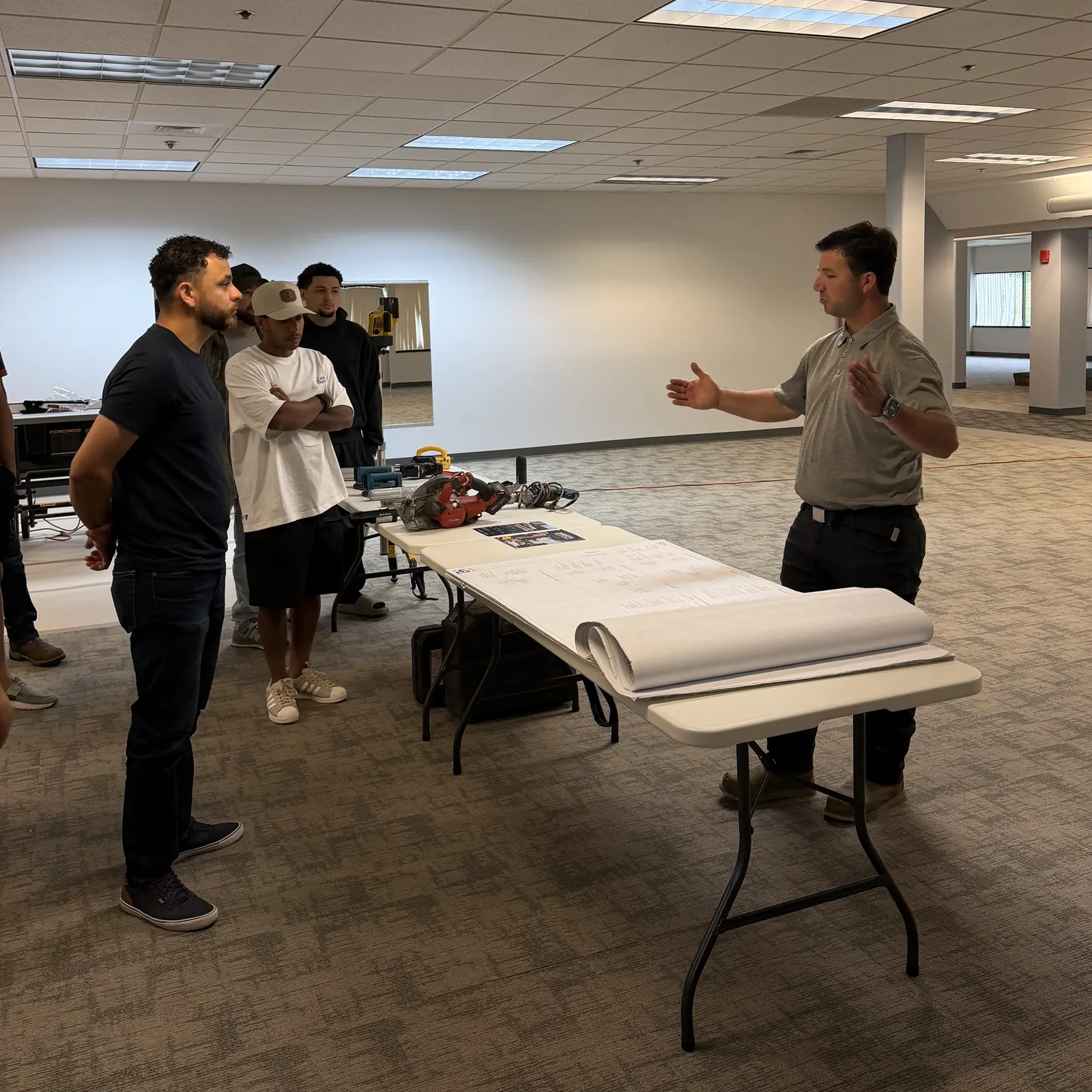 Instructor explaining the drawing set laid out on a table next to the tools