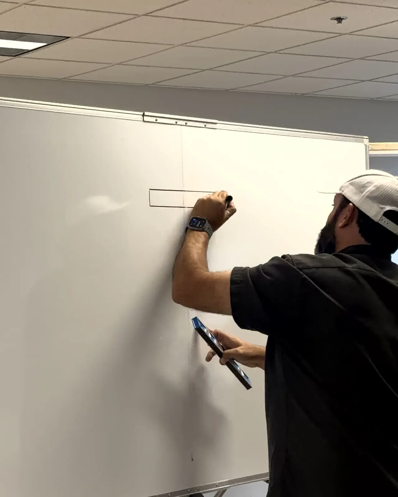 Instructor laying out a component on the whiteboard while holding a level
