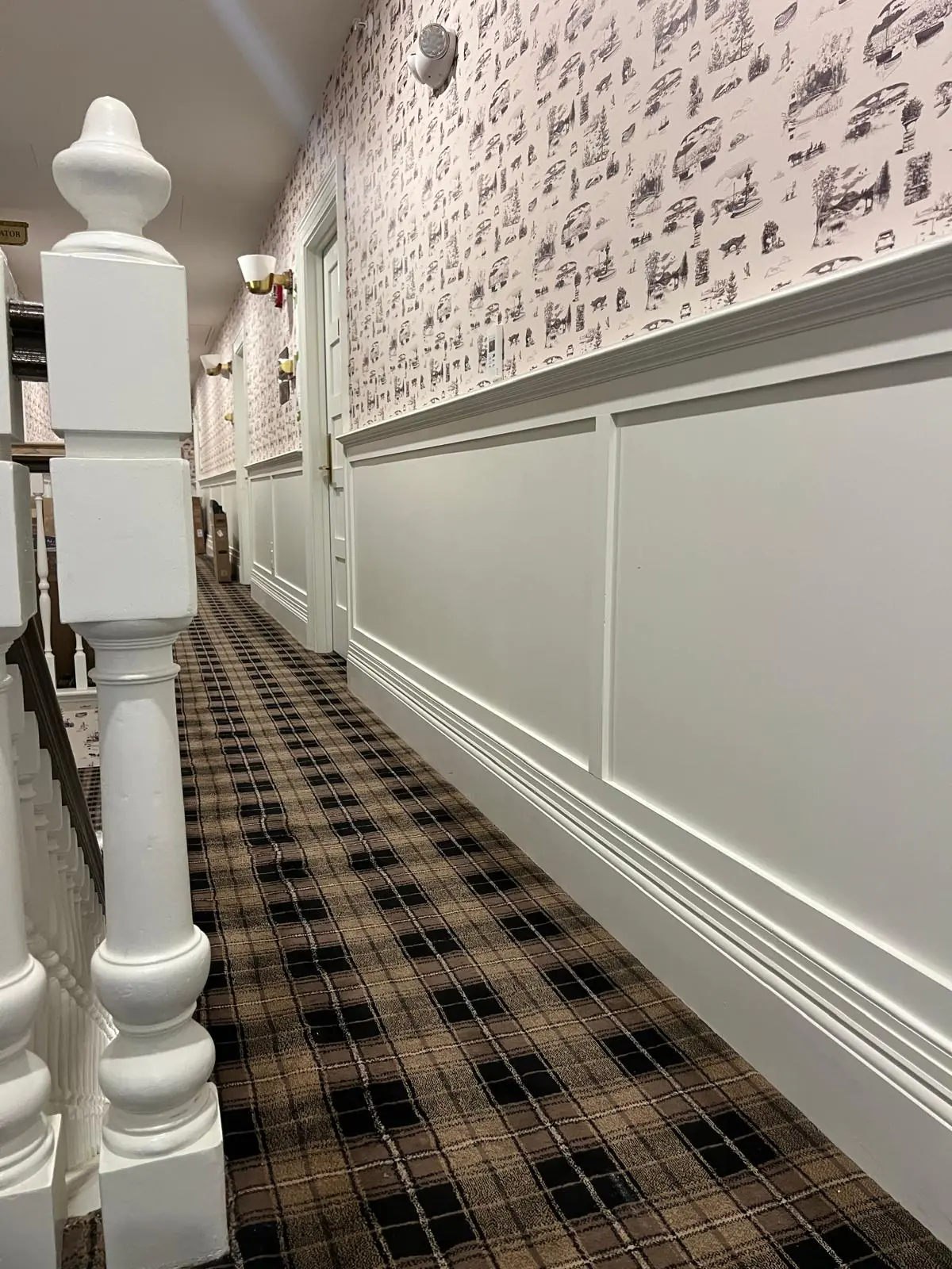 Hotel corridor with column wraps, wainscot paneling, and base installed