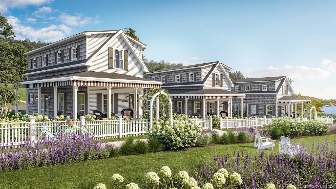 Charming coastal-style cottages with front porches, striped awnings, white picket fences, and landscaped gardens overlooking the water